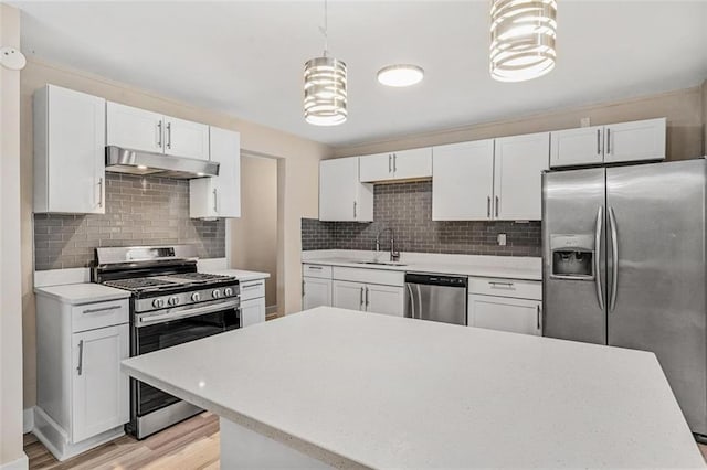 kitchen featuring stainless steel appliances, light countertops, white cabinetry, and under cabinet range hood