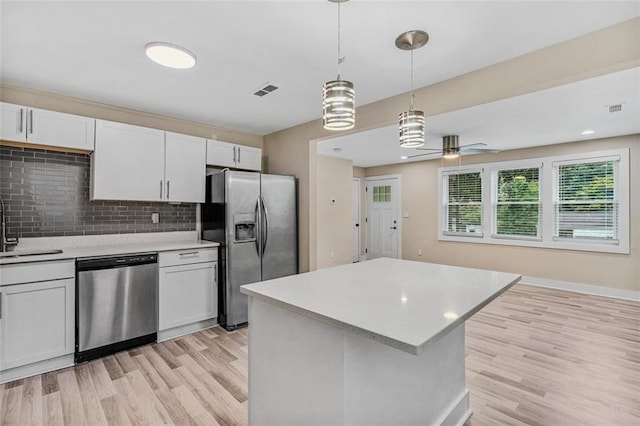 kitchen featuring decorative backsplash, appliances with stainless steel finishes, white cabinets, and light countertops