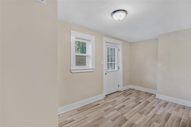 doorway to outside featuring baseboards and light wood-style floors