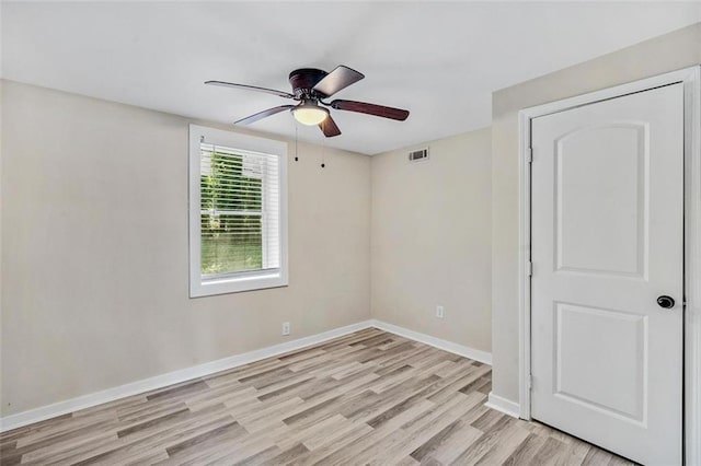 unfurnished room with ceiling fan, light wood-style flooring, visible vents, and baseboards