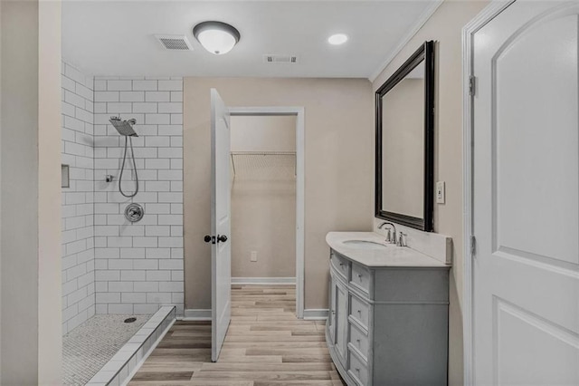 full bathroom with a stall shower, a walk in closet, visible vents, and vanity