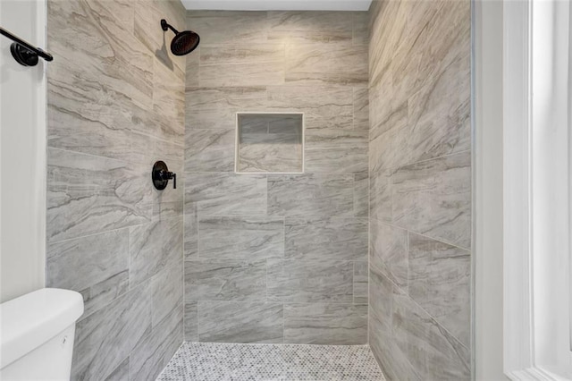 bathroom featuring toilet and tiled shower