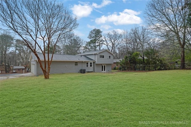 view of yard with driveway, an attached garage, and fence