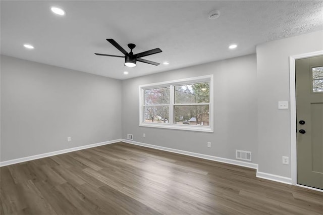 spare room featuring dark wood finished floors, baseboards, and visible vents