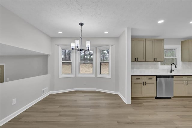 kitchen featuring light wood-type flooring, a sink, light countertops, baseboards, and dishwasher