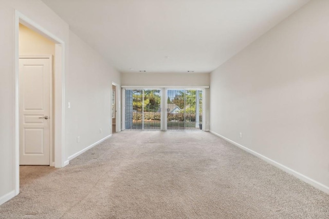 spare room featuring baseboards and carpet