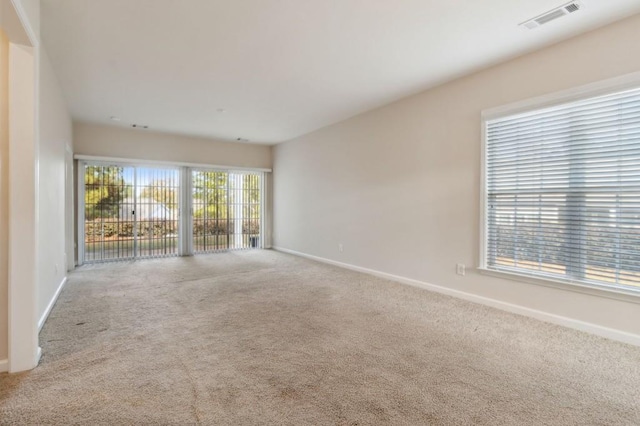 unfurnished room featuring baseboards, carpet, and visible vents