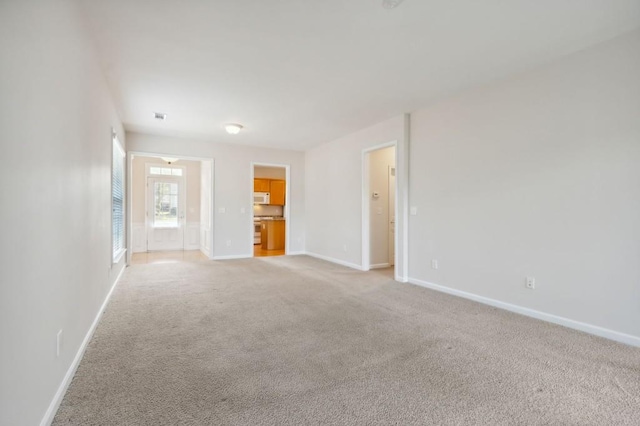 unfurnished room with visible vents, baseboards, and light colored carpet