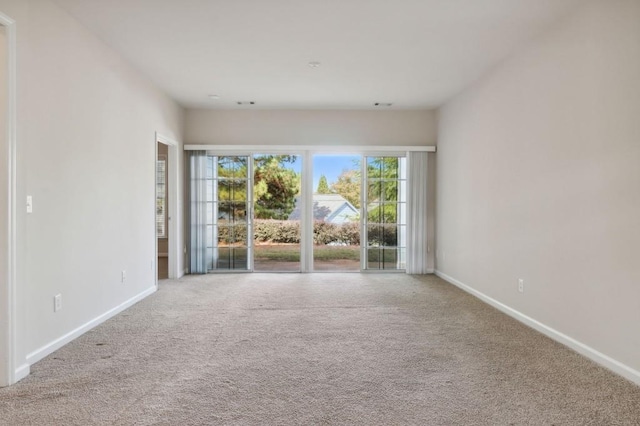 carpeted spare room with baseboards