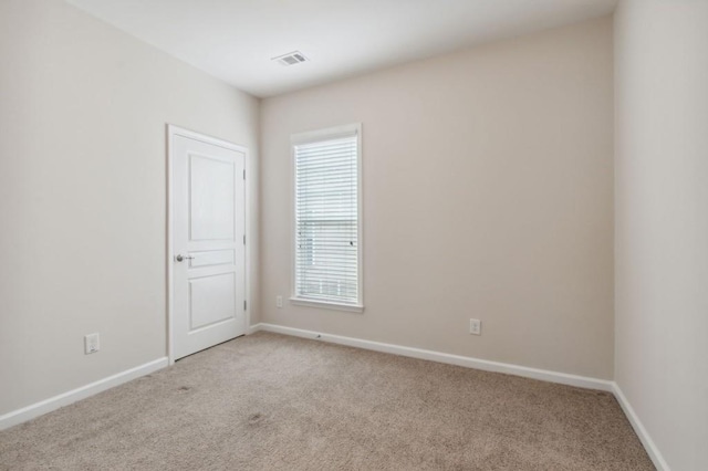 empty room with light carpet, baseboards, and visible vents