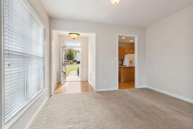 unfurnished room with light carpet, recessed lighting, and baseboards