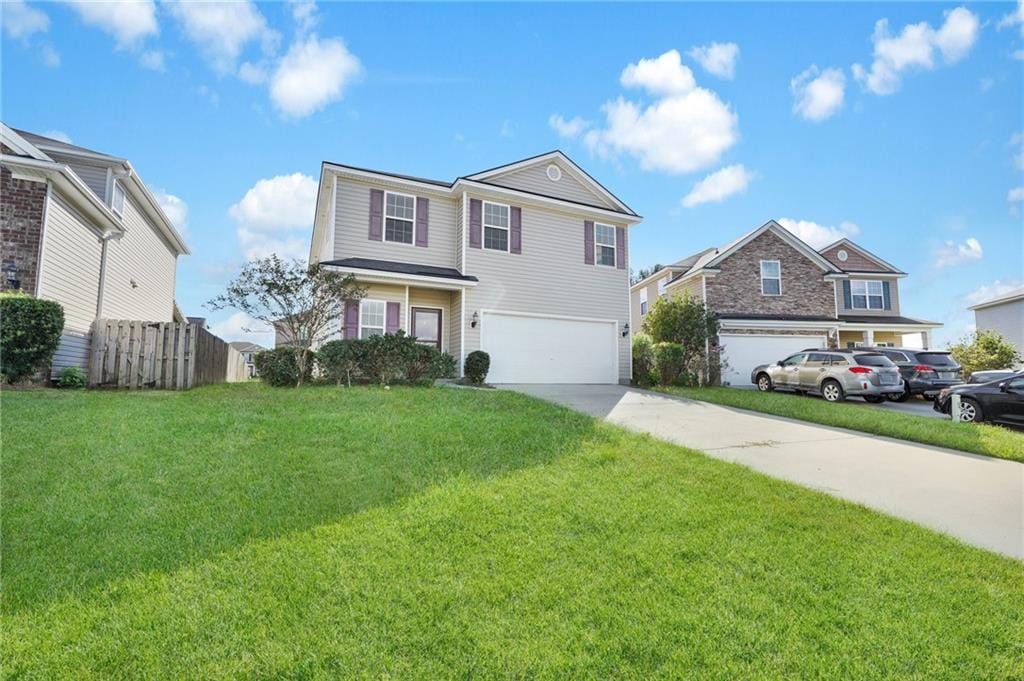 view of property with a garage and a front yard