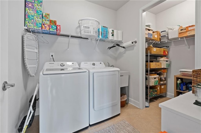 laundry area featuring light tile patterned floors, laundry area, independent washer and dryer, and baseboards