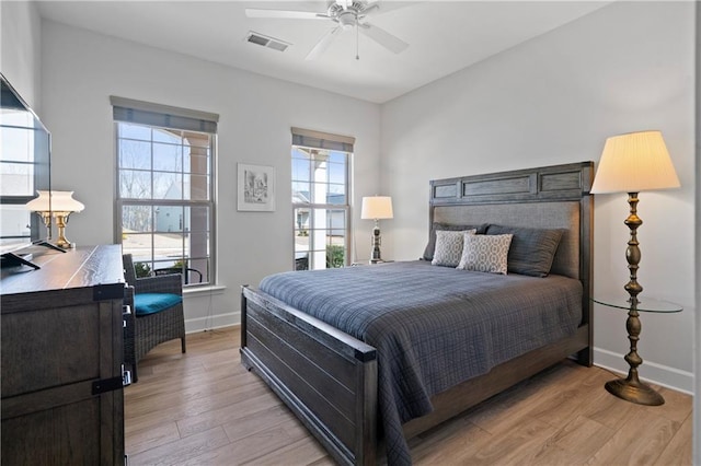 bedroom with light wood-style flooring, visible vents, ceiling fan, and baseboards