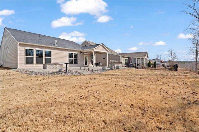 rear view of property featuring a patio area and fence