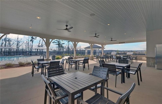 view of patio / terrace featuring outdoor dining area, a ceiling fan, and a community pool