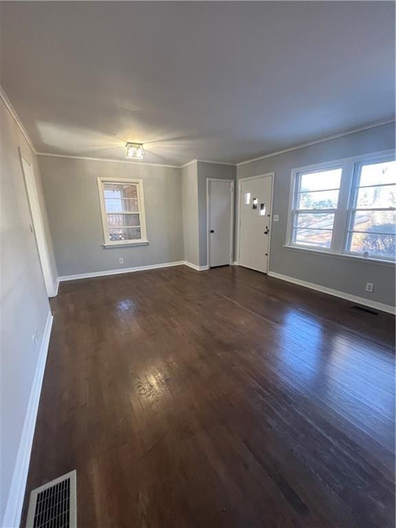 unfurnished living room featuring dark hardwood / wood-style flooring and crown molding