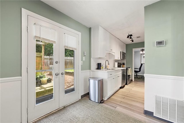 4131 N Gloucester Pl, Atlanta, GA 30341 - kitchen featuring range, stainless steel microwave, ceiling fan, white cabinetry, and light countertops