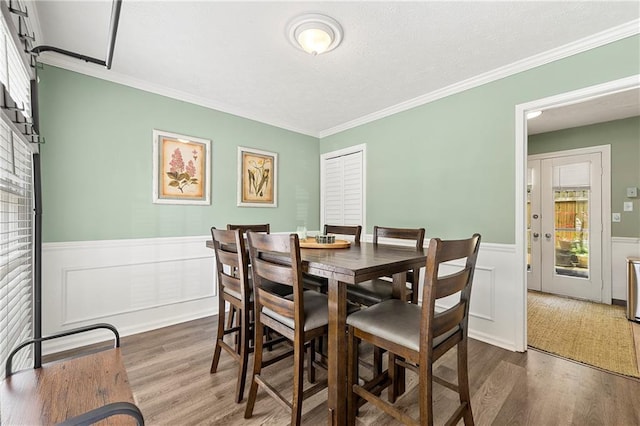 4131 N Gloucester Pl, Atlanta, GA 30341 - dining space with dark wood-style flooring, a wainscoted wall, crown molding, and a decorative wall