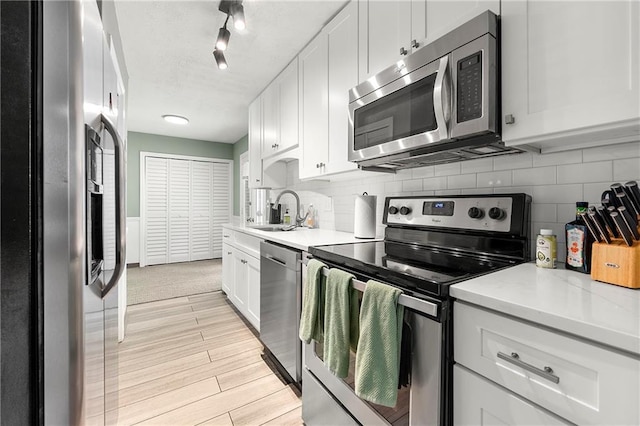 4131 N Gloucester Pl, Atlanta, GA 30341 - kitchen with appliances with stainless steel finishes, a sink, light countertops, decorative backsplash, and white cabinetry