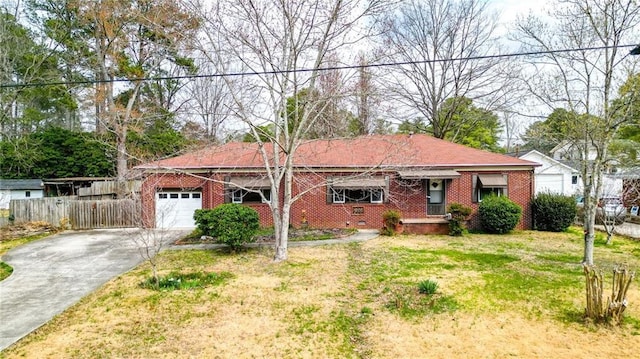 ranch-style house featuring a front yard, fence, an attached garage, concrete driveway, and brick siding