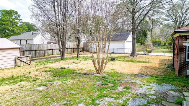 view of yard featuring a garage, an outbuilding, and a fenced backyard