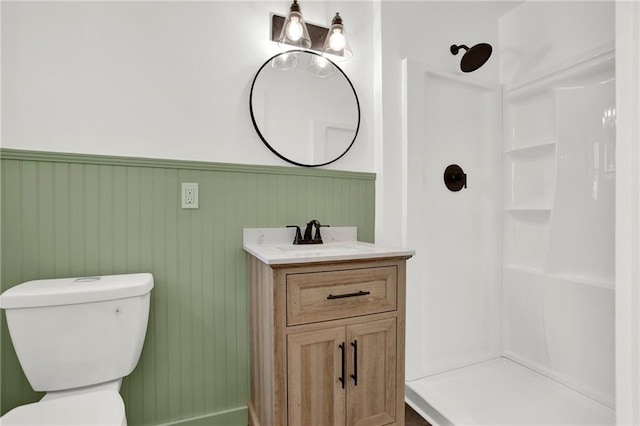 full bathroom with a wainscoted wall, vanity, toilet, and a shower