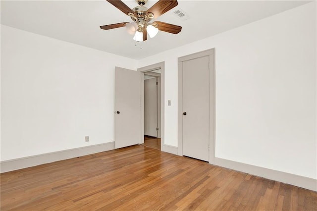 spare room featuring visible vents, baseboards, light wood-type flooring, and ceiling fan