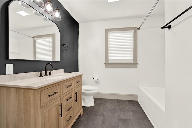 bathroom with baseboards, toilet, a healthy amount of sunlight, and vanity