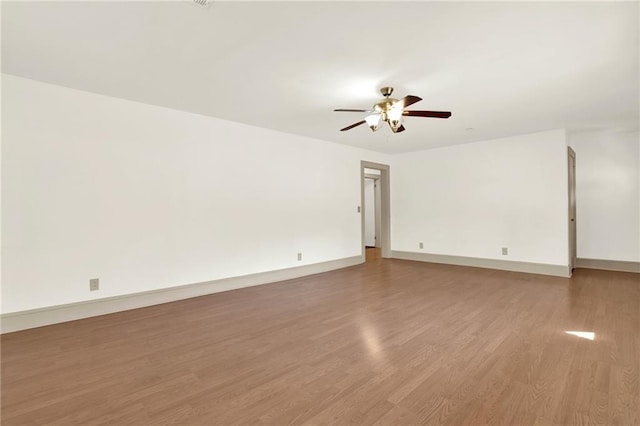 unfurnished room with light wood finished floors, baseboards, and ceiling fan