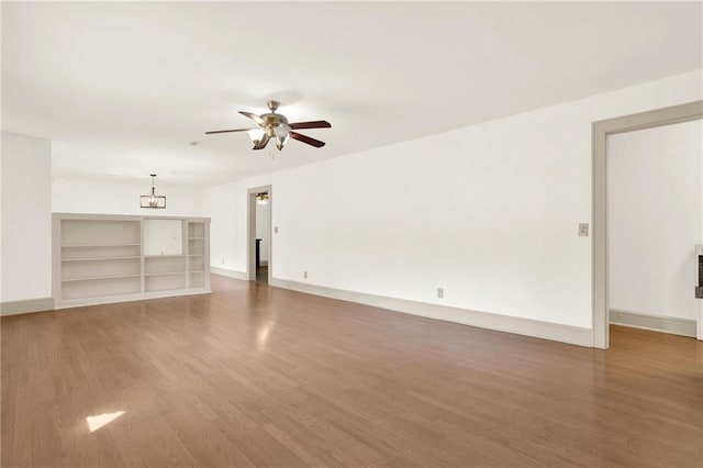 unfurnished living room with baseboards, a ceiling fan, and wood finished floors