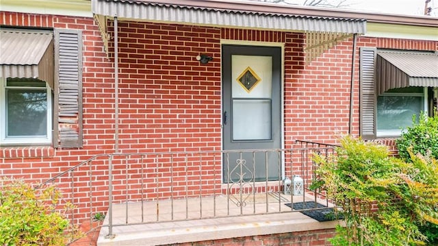 doorway to property with brick siding