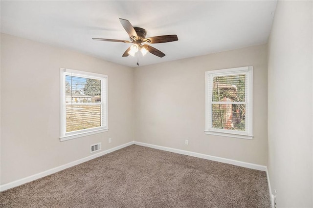 carpeted spare room featuring ceiling fan