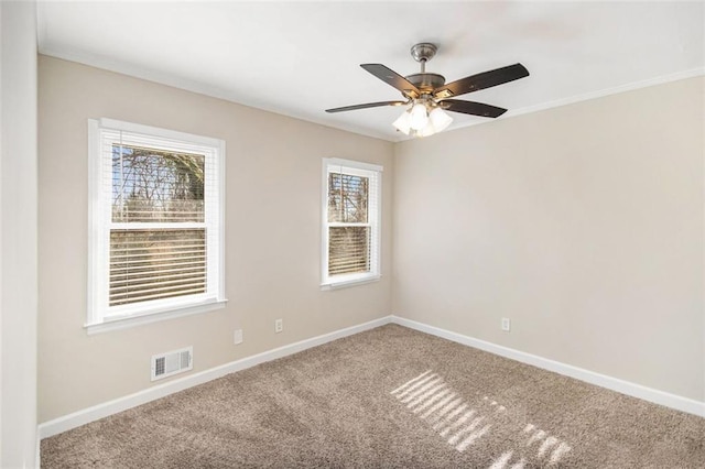 carpeted spare room featuring ceiling fan and crown molding