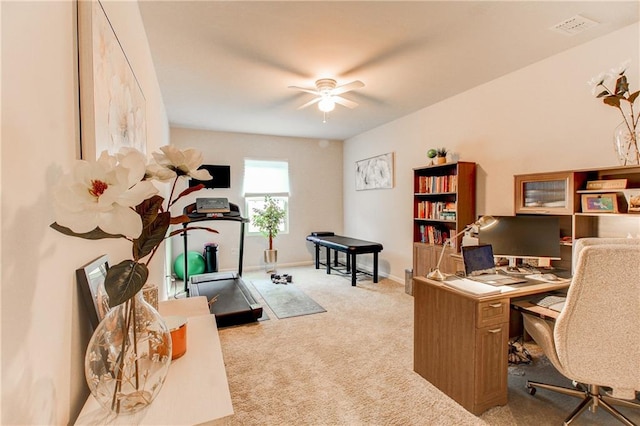 carpeted home office featuring ceiling fan