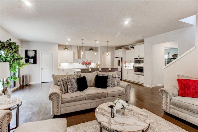 living room with dark hardwood / wood-style floors and a textured ceiling