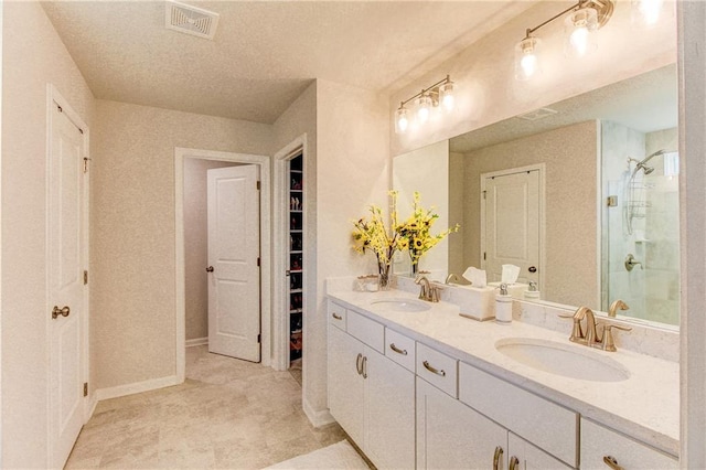 bathroom featuring a shower with door and vanity