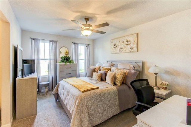 carpeted bedroom featuring a textured ceiling and ceiling fan