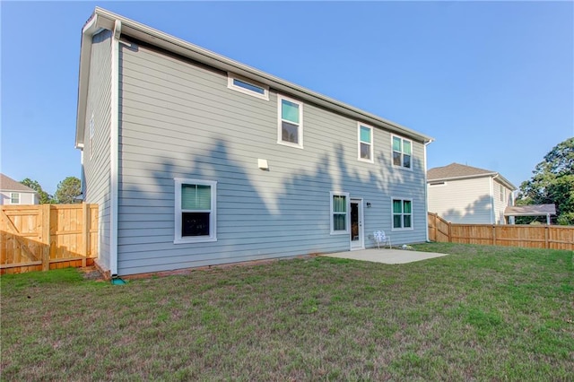 rear view of property featuring a lawn and a patio area