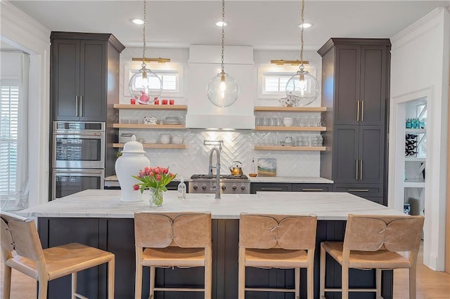 kitchen featuring light stone countertops, stainless steel appliances, a breakfast bar, and decorative backsplash