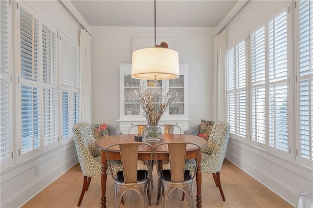 dining space featuring crown molding, a wealth of natural light, and light wood-type flooring