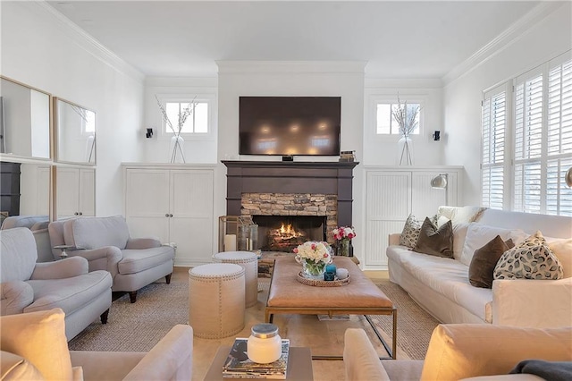 living room with ornamental molding, a stone fireplace, and plenty of natural light