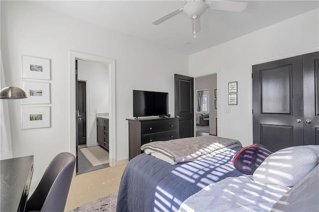 bedroom featuring light colored carpet, ceiling fan, and ensuite bathroom