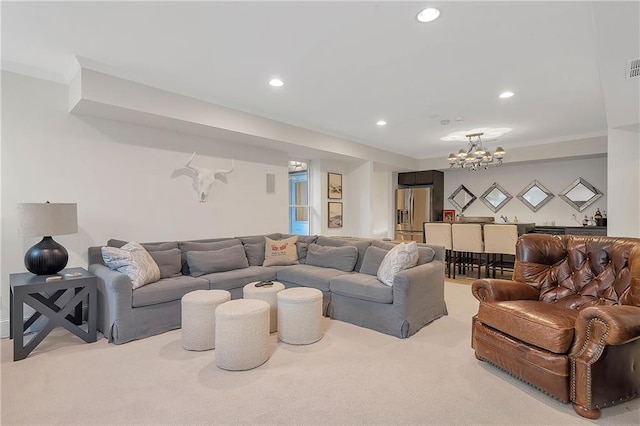 living room featuring ornamental molding, a chandelier, and light carpet