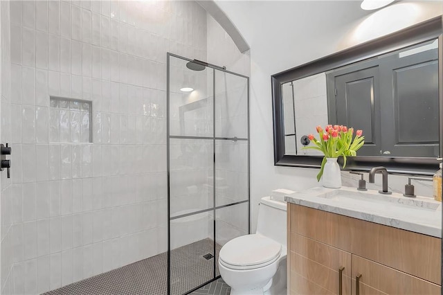 bathroom featuring vanity, an enclosed shower, and toilet