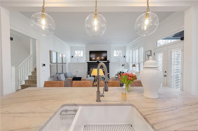 kitchen featuring sink, ornamental molding, and hanging light fixtures