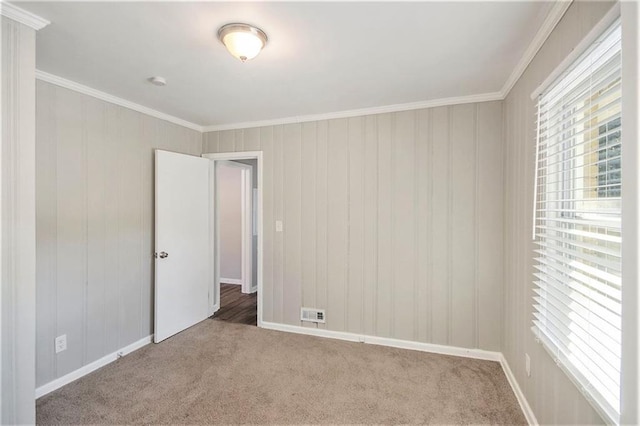 unfurnished room with ornamental molding and carpet flooring