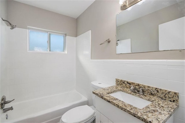 full bathroom featuring toilet, vanity, tile walls, and tiled shower / bath