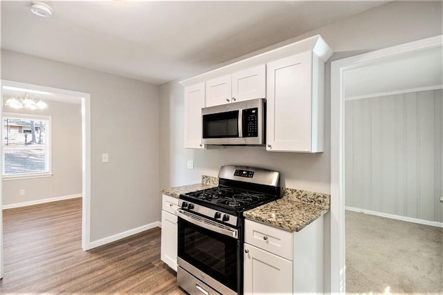 kitchen with white cabinets, light stone counters, and appliances with stainless steel finishes