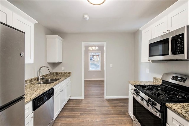 kitchen featuring sink, white cabinets, light stone counters, dark hardwood / wood-style flooring, and appliances with stainless steel finishes